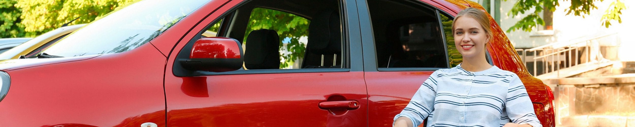 Woman in wheelchair in front of car