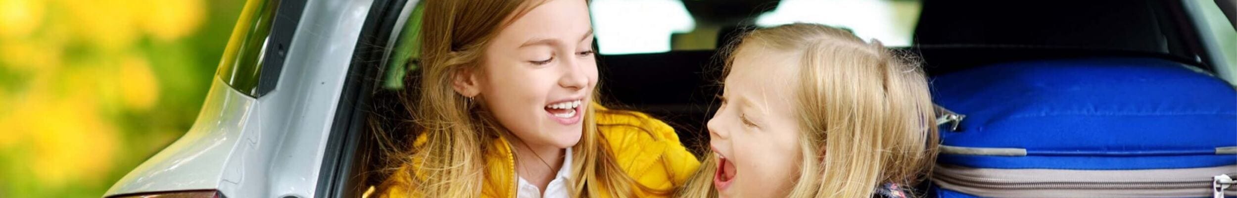Two little girls in back of packed car boot