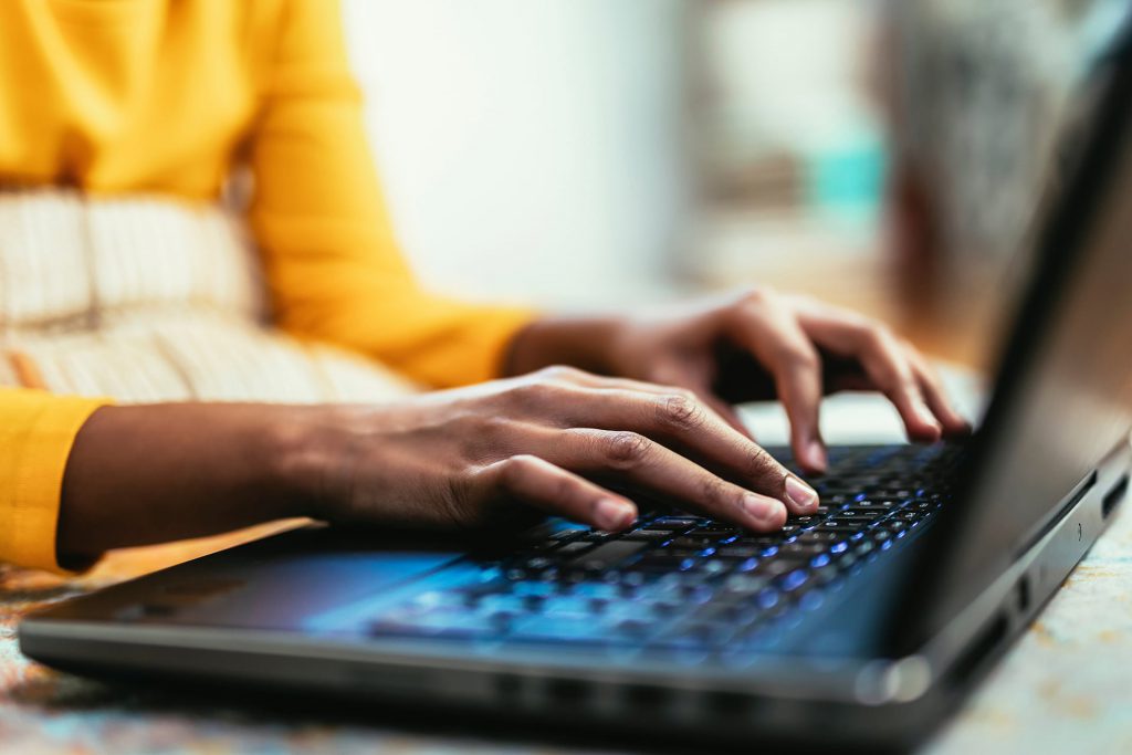 hands typing on a laptop