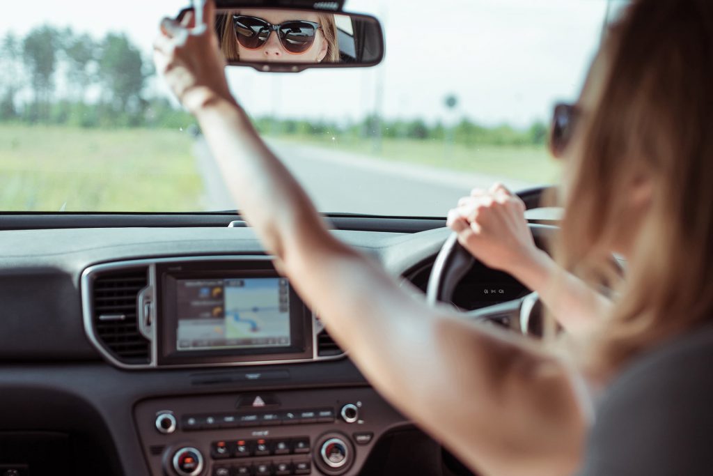 Woman looking in rear view mirror