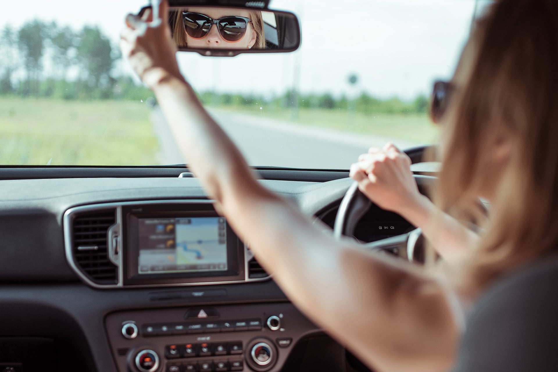 Woman looking in rear view mirror