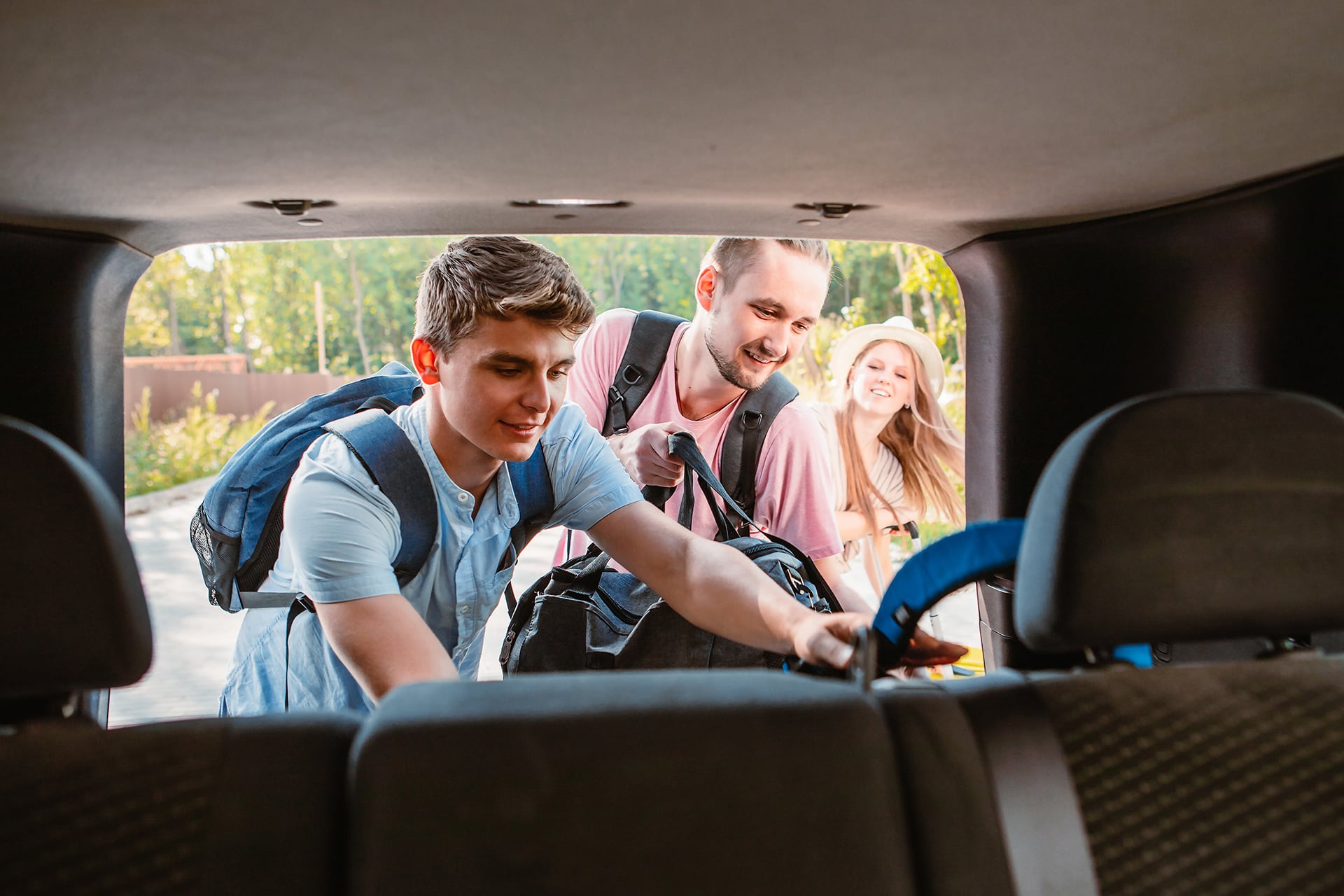 friends putting their bags in the boot