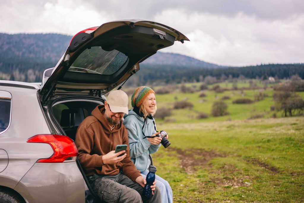 Romantic happy middle age caucasian couple traveling by car sitting in car