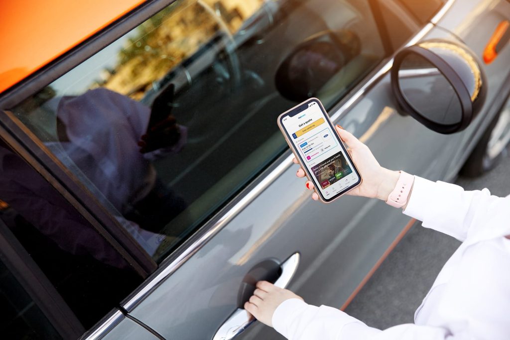 Mobile phone in hand with the Dayinsure mobile app on screen